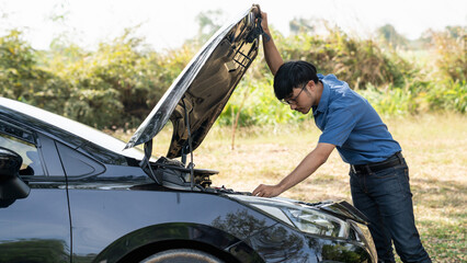 Mechanic or driver providing roadside assistance by changing a flat tire and performing minor...