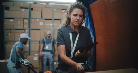 Logistics Retail Warehouse: Female Manager with Digital Tablet Scanning Cardboard Boxes Using Barcode Scanner. Diverse Employees Unloading Pallet Truck with Online Orders, Purchases, E-Commerce Goods. © Framestock