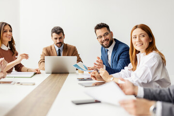 Executives in a boardroom sitting at conference table and collaborating on a project together.