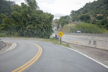 Sinalização rodoviária indicando pedágio a 1 km com opção de cobrança automática à direita. Foto ideal para temas de mobilidade, transporte rodoviário e infraestrutura no Brasil.