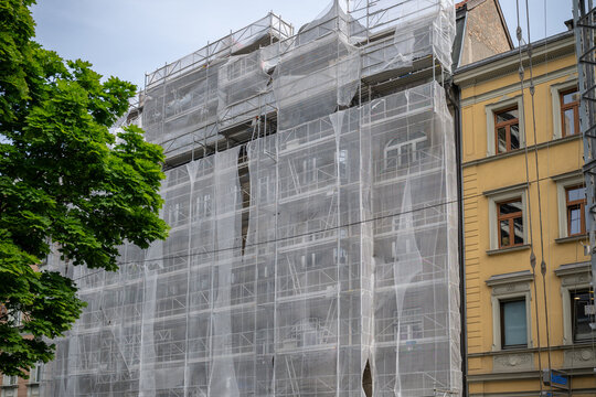 Historic building under renovation covered with scaffolding and safety netting