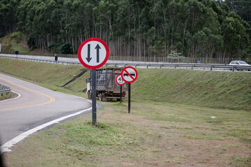 Sinalização rodoviária com limites de velocidade distintos para veículos leves (80 km/h) e pesados (60 km/h), em estrada brasileira. Ideal para temas de trânsito, segurança viária e transporte.