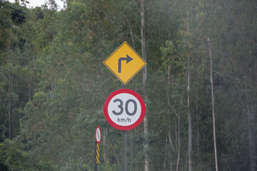 Sinalização rodoviária com limites de velocidade distintos para veículos leves (80 km/h) e...