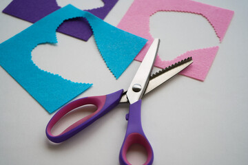 The scissors are lying on the pieces of felt. Needlework and sewing.