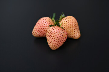 delicious fresh pineberries on black background close-up