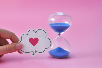 an hourglass and a heart next to it are symbols of the duration of human life or the time of love