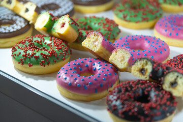 Colorful donuts displayed in a bakery at midday