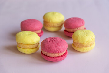 Colorful macarons arranged in a circular pattern on a light surface