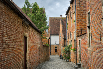 Leuven, Belgium: Historic red brick buildings, green shrubs, courtyard.

