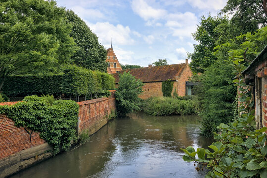Groot Begijnhof Leuven, Belgium: Tranquil canal, historic brick buildings, and lush greenery.