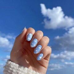Hand with Cloud Nail Art Against a Beautiful Blue Sky Background