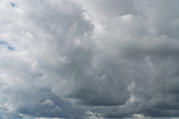 Stormy sky with dark, snowy clouds on a spring day. Clouds are floating across the sky. Dark blue...
