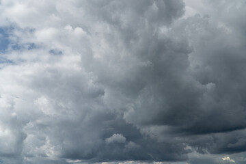Stormy sky with dark, snowy clouds on a spring day. Clouds are floating across the sky. Dark blue...