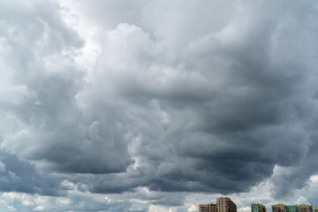 Stormy sky with dark, snowy clouds on a spring day. Clouds are floating across the sky. Dark blue...
