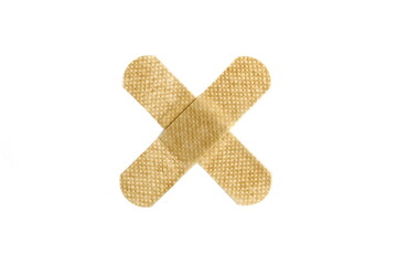 On a white isolated background there is an adhesive plaster in the form of a cross.	
