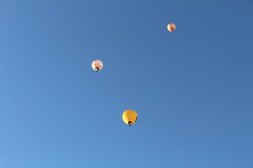 Three hot air balloons are flying against the sky.