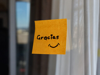 A yellow sticky note with a thank you message is displayed on glass