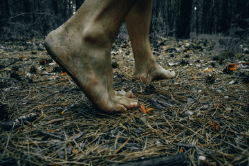Feet man walking on ground in forest. Creepy Halloween concept.