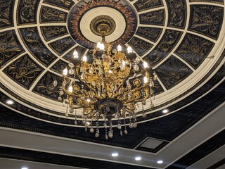 ornate,gilded,chandelier,large,opulent,starburst,pattern,intricate,decorative,high-contrast,dark...