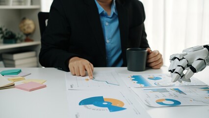 A business professional is deeply engaged in analyzing reports and data, showcasing the dynamic...