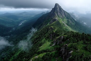 Obraz premium Serene green mountain peak in foggy aerial landscape 