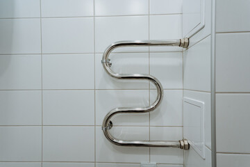 A stylish towel rack on a white tiled wall enhances both functionality and aesthetics in a modern...