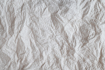 Crumpled white embossed tissue paper with dot pattern

