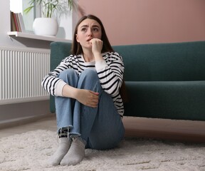 Woman suffering from paranoia on floor at home