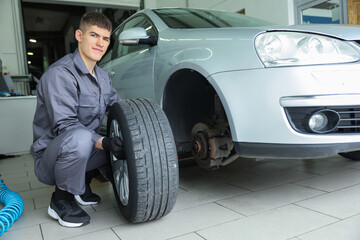 Professional mechanic changing tire at car service