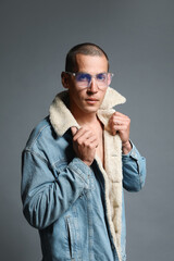 Fashionable portrait of handsome man in stylish outfit on grey background