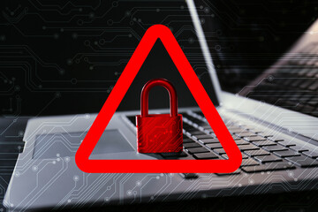 Cyber attack alert notification. Red warning sign with padlock and circuit board pattern. Laptop on...