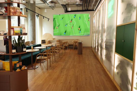 Broadcasting soccer match on TV set in bar - Powered by Adobe