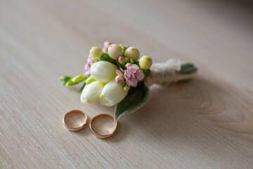 Beautiful wedding rings with delicate flower boutonniere