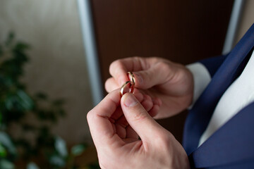 Businessman Holding Wedding Rings Between Fingers