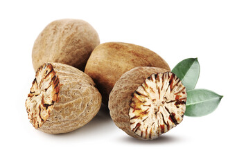 Nutmeg seeds with green leaves on white background. Aromatic spice