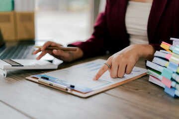 Young Asian woman doing financial accounting and taxes for a company Organizing account analysis reports Investment information Financial and tax system concepts