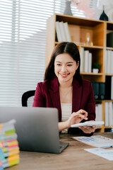 Young Asian woman doing financial accounting and taxes for a company Organizing account analysis reports Investment information Financial and tax system concepts