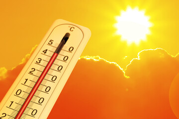 Extremely high temperature on thermometer against orange sky on sunny day. Severely hot summer...