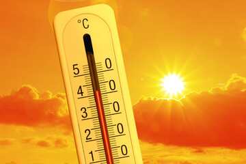 High temperature on thermometer against orange sky on sunny day. Hot summer weather