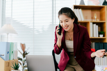 Asian businesswoman using smartphone to communicate business tasks in office