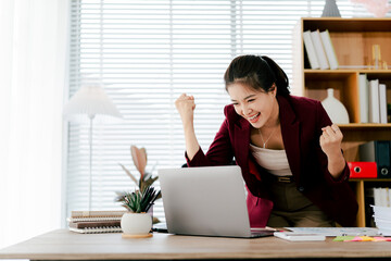 Asian woman is excited about her victory in the office. Female employees are very happy about their completed project.