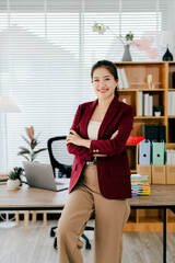 Confident Asian female secretary looking at camera in office. Young woman checking business...