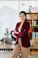 Confident Asian female secretary looking at camera in office. Young woman checking business...