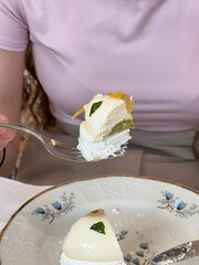 Girl Holding a Fork with Slice of Mousse Cake in Café