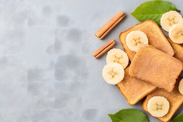 Fototapeta premium French toast with banana slices and cinnamon sticks on gray stone background, Rustic breakfast plate, Flat lay overhead food concept, Copy space for text