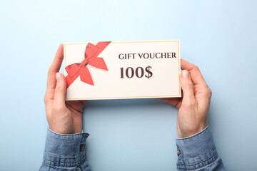 Top view of woman holding gift voucher with 500 value lettering on white background