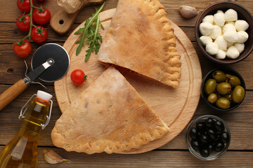 Pizza calzone with basil leaves close up with restaurant background. classic italian food