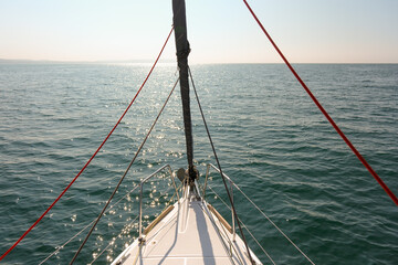 Adventure on a sailboat, sailing into the horizon on a summers day showing the bow of a yacht with...