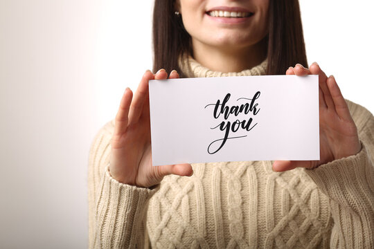 Top view of woman holding gift voucher lettering on white background