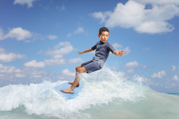Kid in a wetsuit riding a surfboard